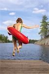 Woman Jumping into Lake with Inner Tube