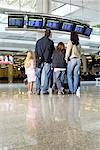 Famille regarder des données de vol dans l'aéroport