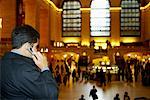 Homme à l'aide de téléphones cellulaires à Grand Central Station, New York, États-Unis