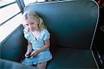 Fille assise sur les autobus scolaires