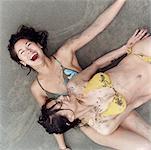 Deux femmes bronzer sur la plage et rire