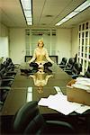 Woman Meditating in Boardroom