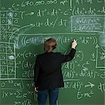 Man Writing on Chalkboard