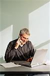 Businessman With Laptop Computer Talking On Cell Phone