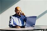 Businessman Using Laptop Computer And Cellular Phone
