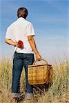 Man Holding Picnic Basket and Flower