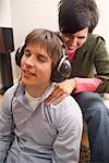 Man Listening to Music and Receiving Massage from Woman