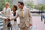 Group of Business People Shaking Hands on Street