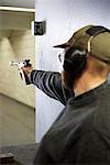 Man Shooting Handgun in Firing Booth