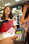 Women Waiting while Man Uses Debit Machine