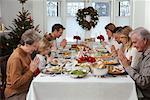 Family Praying at Christmas Dinner