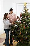 Mutter und Tochter schmücken Weihnachtsbaum