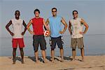 Portrait de groupe des hommes sur la plage