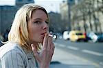 Woman Sitting on Curb Smoking Cigarette, Paris, France