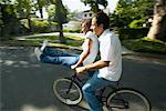 Couple Riding on Bicycle Together, Woman Sitting on Handlebars