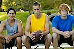 Three Young Men Sitting In Park