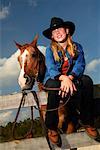 Portrait de jeune fille, assis sur la clôture avec des chevaux