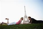 Couple allongé par la tour Eiffel, Paris, France