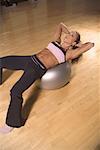 Femme faire des redressements assis sur le ballon d'exercice