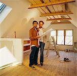 Portrait of Couple Looking at Floor Plans