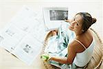 Woman Reading Newspaper and Eating Apple