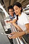 Man and Woman Looking at Cellular Phone in Train Station