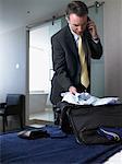 Businessman Packing Suitcase in Hotel Room