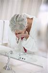 Woman Washing Face in Sink