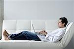 Man Using Laptop on Sofa