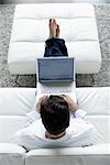 Man Using Laptop on Sofa