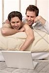 Male Couple Using Laptop and Phone