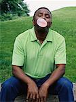 Man Sitting Blowing Bubbles