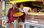 Men with Pizza in Front of Pizza Business