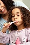 Mädchen putzen Zähne mit Mutter