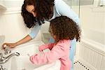 Girl Brushing Teeth with Mother