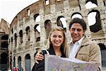 Couple Looking at Map by Colosseum, Rome, Italy