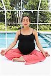 Pregnant Woman Meditating by Swimming Pool
