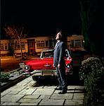 Man Standing in Driveway at Night