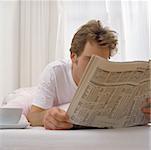 Man in bed with tea and paper