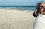 Senior woman at beach looking at camera