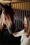 Jeune femme caresser le visage du cheval