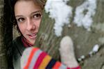 Femme en gants derrière un arbre