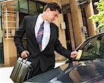 Businessman Looking at Parking Ticket