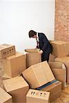 Man Looking in Cardboard Boxes