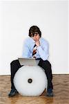 Businessman Sitting on Bubble Wrap Roll