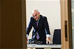 Businessman Leaning on Desk