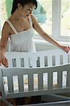 Pregnant Woman Looking into Bassinet