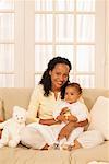 Portrait of Woman Holding Baby, Sitting on Couch