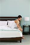 Man Sitting on Edge of Bed