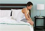 Man Sitting on Edge of Bed